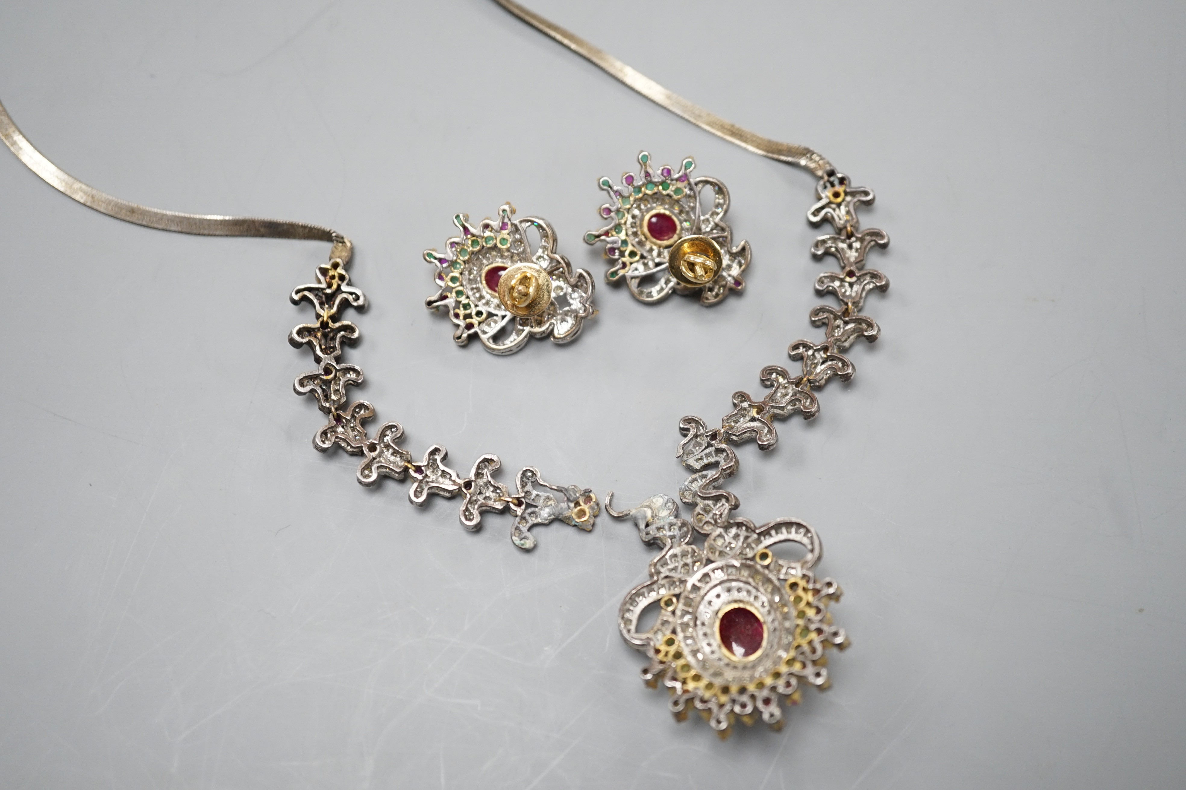 An Indian white and yellow metal, diamond, ruby and gem set necklace, 46cm and pair of matching earrings.